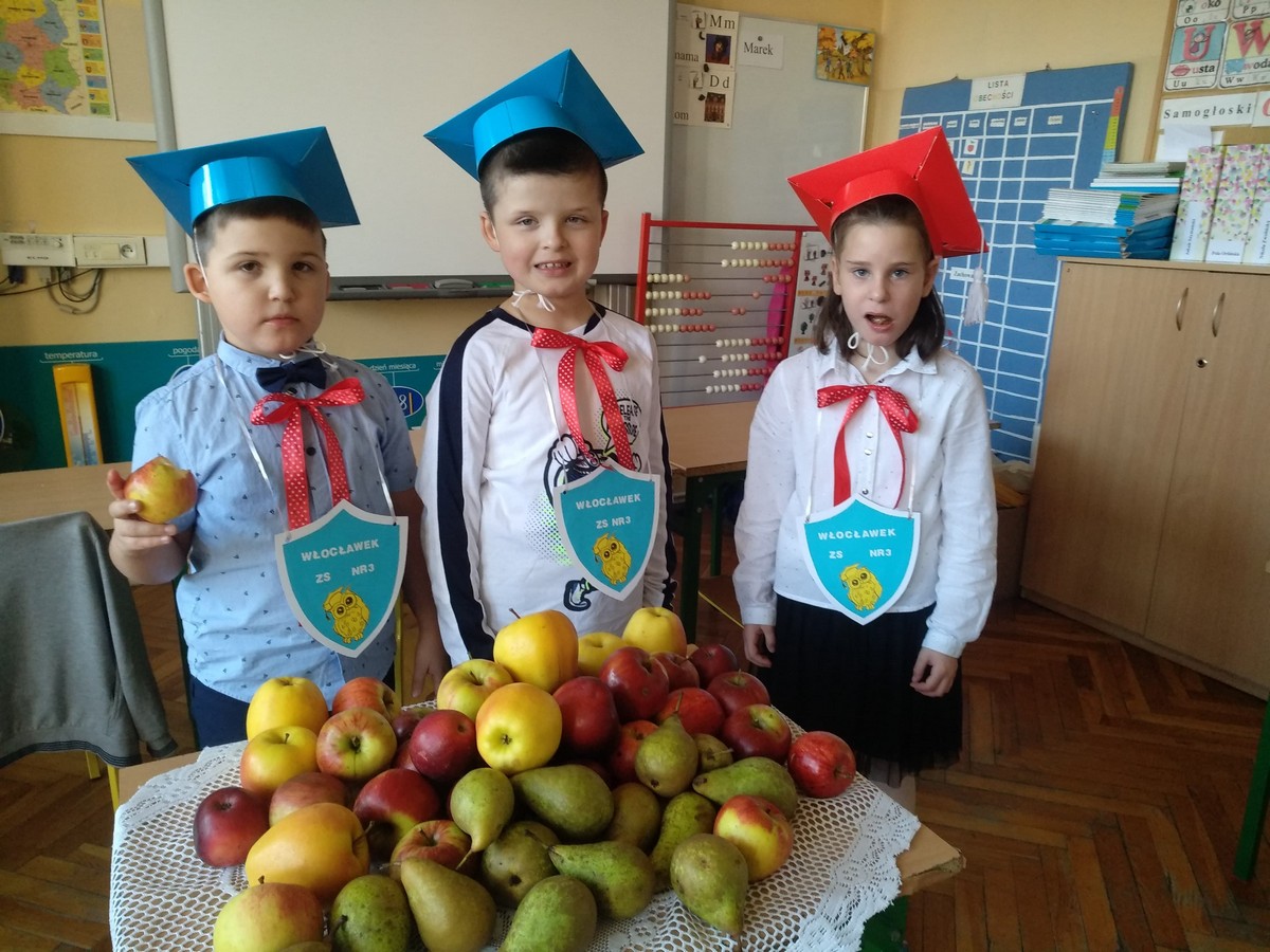 Uczniowie stojący przy owocach