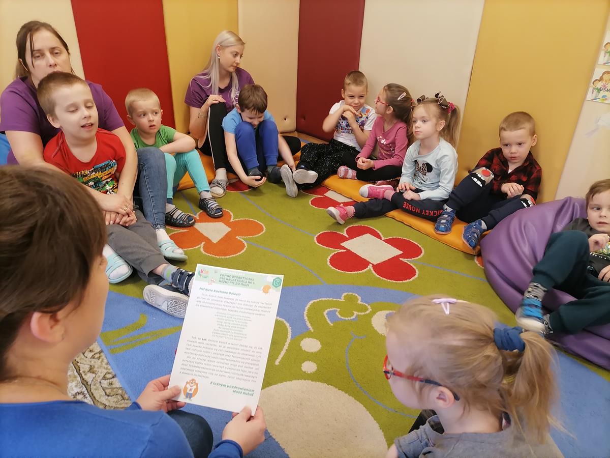 Dzieci i nauczyciele siedzący w kręgu