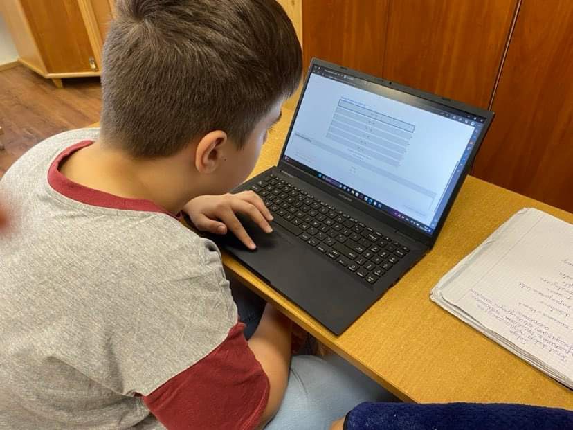 Uczeń pracuje przy laptopie